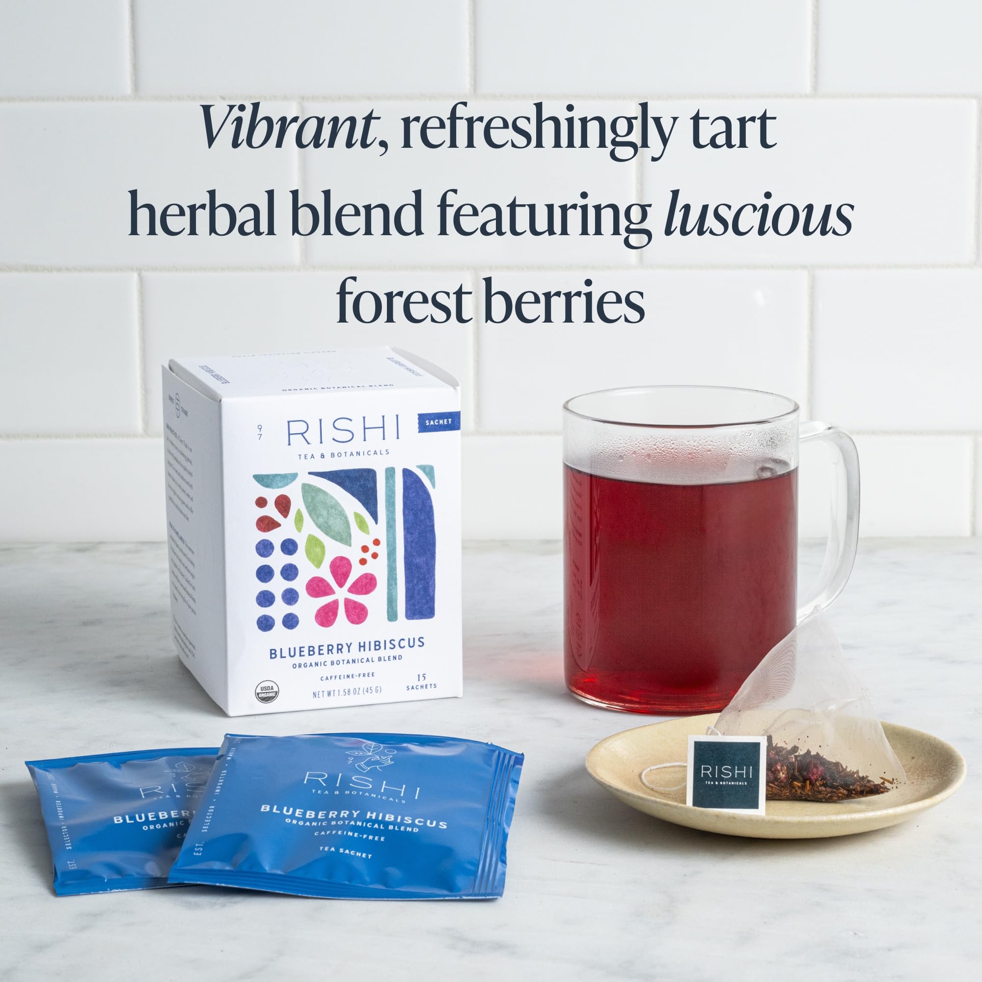 Blueberry Hibiscus berries featured in a glass tea setting.