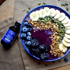 Royal Rose blueberry syrup being poured, ideal for cocktails and sparkling drinks.