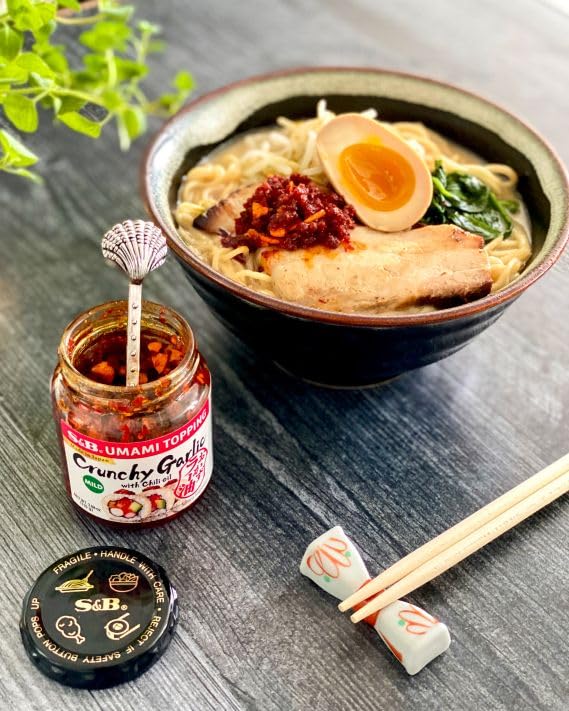 S&B chili oil over pasta, enhancing texture with crisp garlic and warmth.