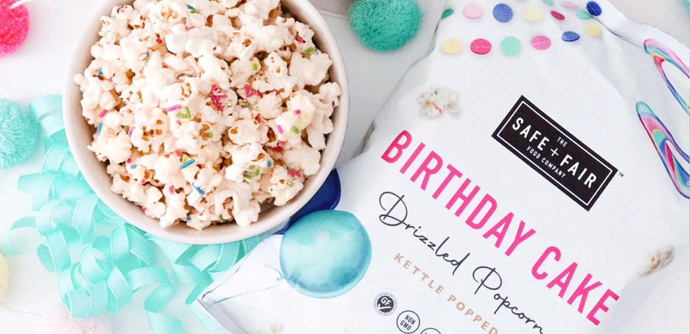 Open six-pack box of Safe + Fair Birthday Cake Drizzled Popcorn 5.5 oz bags