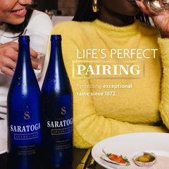Saratoga bottle being poured into a glass, crisp bubbles.