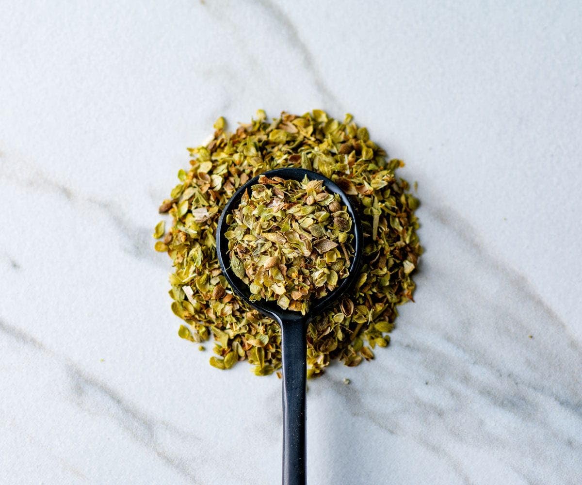 Savory Spice Greek oregano leaves closeup, vibrant aroma ideal for roasting vegetables and marinades.