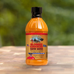 Label of Slobber Knocker Cajun sauce from SBO brand for authentic Louisiana style.