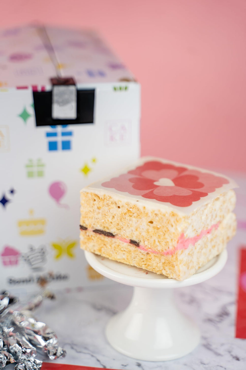 Inside the Send A Cake Roses & Charms gift box reveals treats and keepsakes.