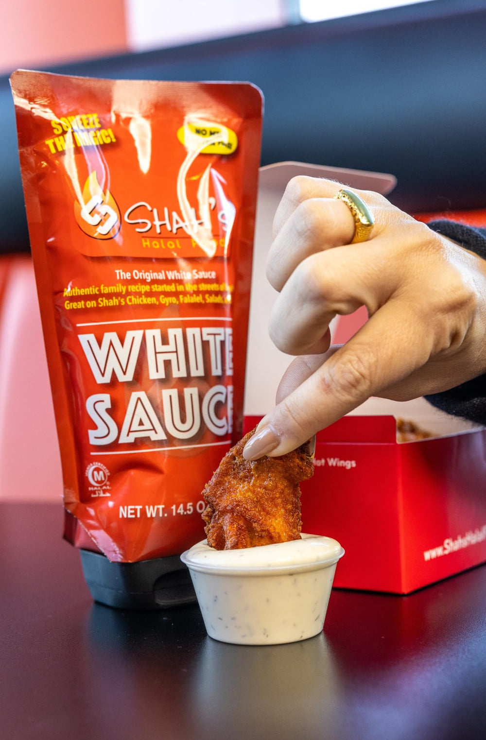 SHAH'S HALAL FOOD White Sauce drizzled over gyros to balance bold flavors.