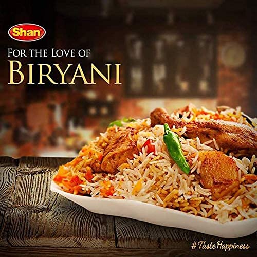 Shan Biryani Masala spice blend on a wooden spoon for effortless biryani seasoning.