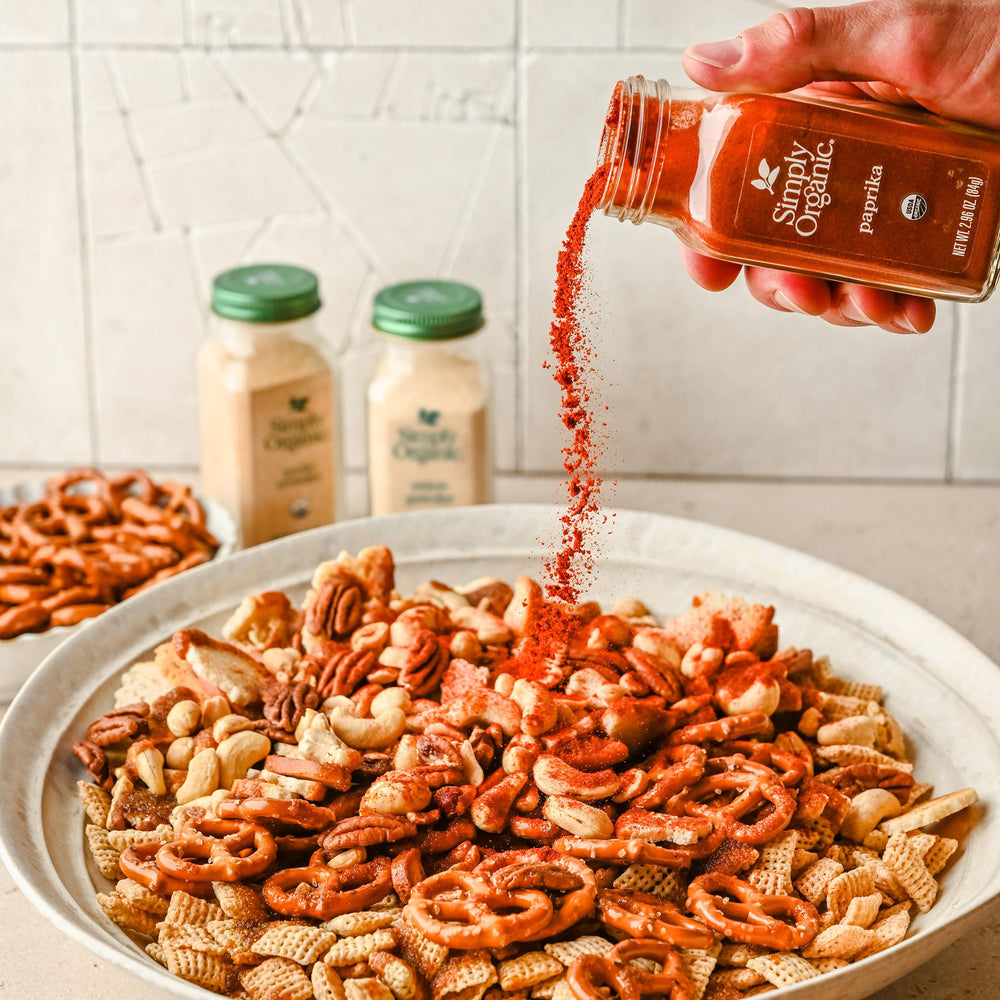 Spoon dispensing Simply Organic paprika ground for precise seasoning