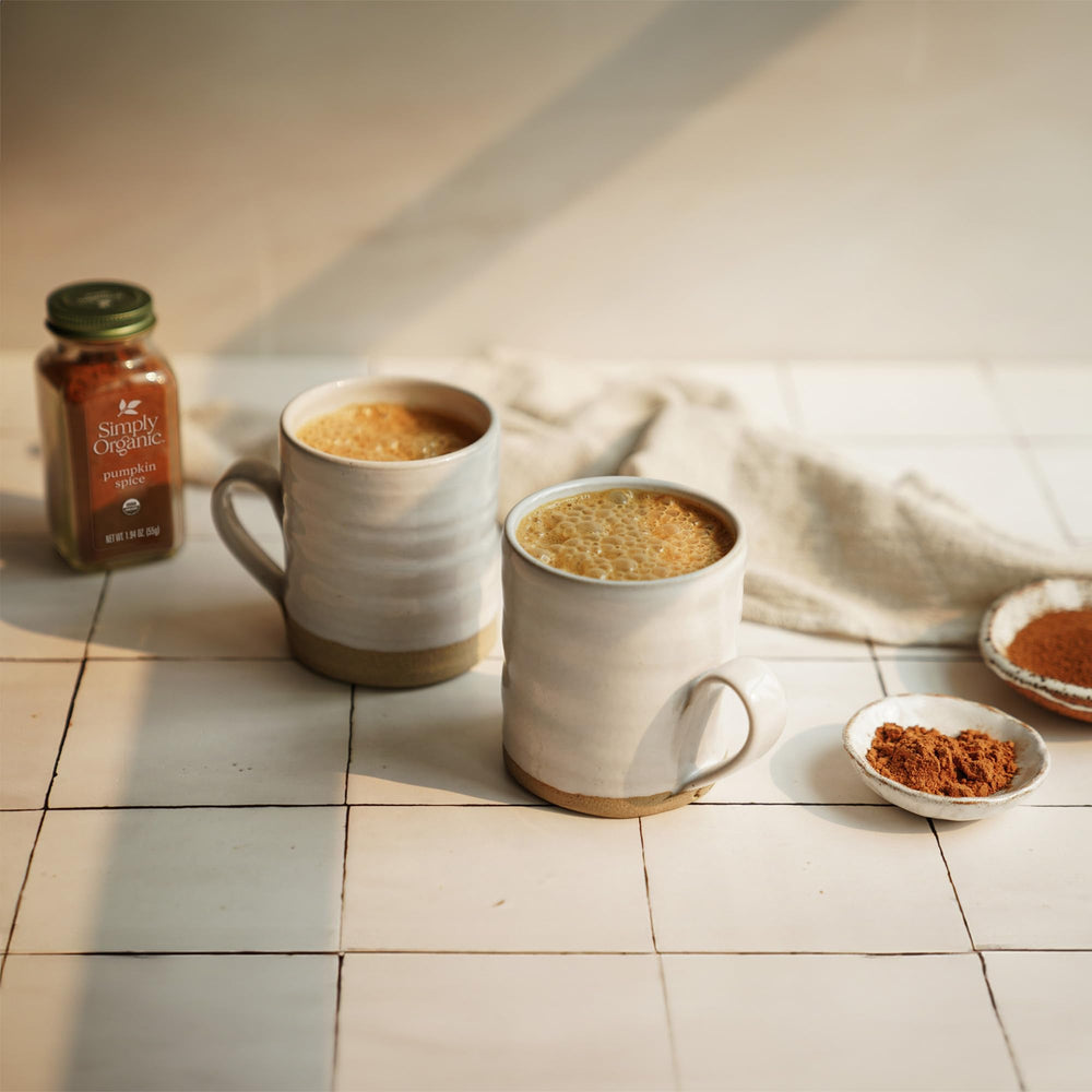 Measuring spoon with Simply Organic Pumpkin Spice over a mixing bowl.