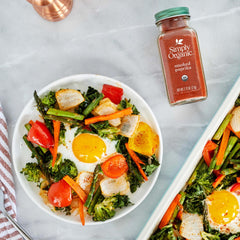 Pouring Simply Organic smoked paprika from a bottle to season roasted vegetables