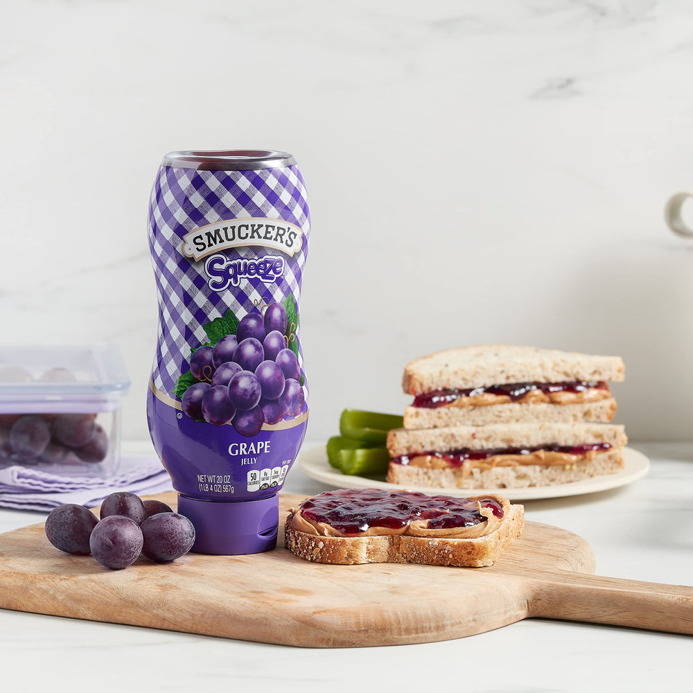 Smooth pour action of Smucker's grape jelly being squeezed.