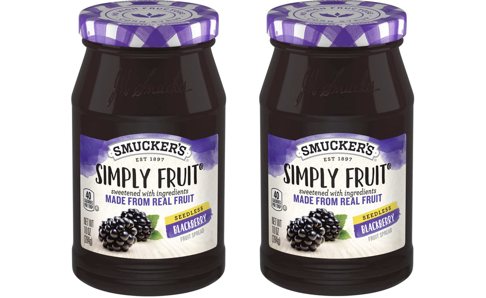 Spreading Smucker's Simply Fruit Seedless Blackberry Spread on bread for breakfast.