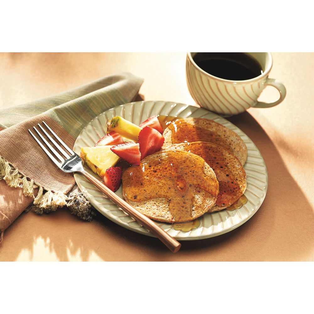 Pouring action of Smucker's Sugar Free Syrup over breakfast items.