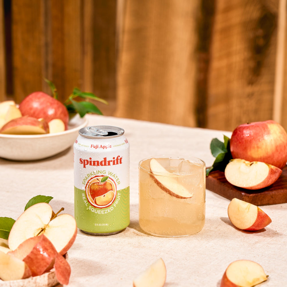 Spindrift Fuji Apple 12-ounce can beside a glass for quick hydration.
