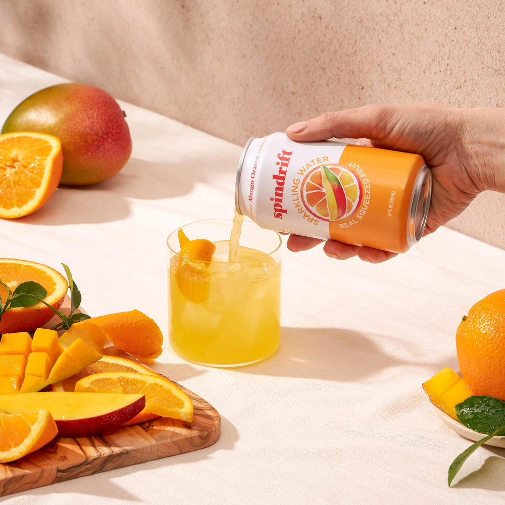 Spindrift Mango Orange sparkling bubbles in glass signaling light, crisp carbonation.