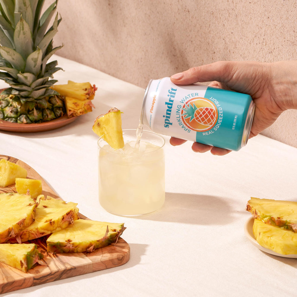 Chilled Spindrift Pineapple Sparkling Water cans in fridge for a sunny day.