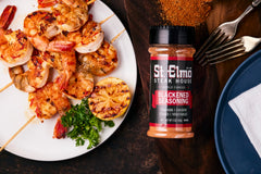St. Elmo Blackened Seasoning kitchen scene demonstrates versatile use on vegetables and seafood.
