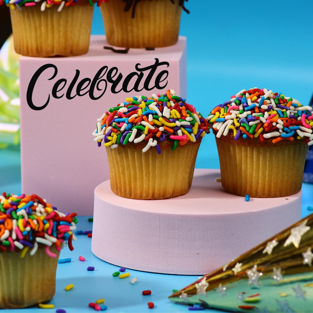 Celebration-ready Stern's Bakery cupcakes displayed on a table with candles.