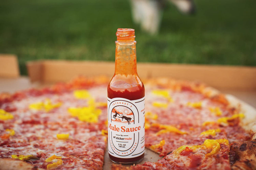 Close-up of Mule Sauce label highlighting premium peppers and branding.