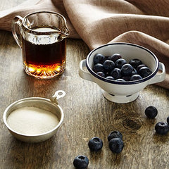 Stonewall Kitchen Maple Blueberry Syrup poured over pancakes for a flavorful breakfast.