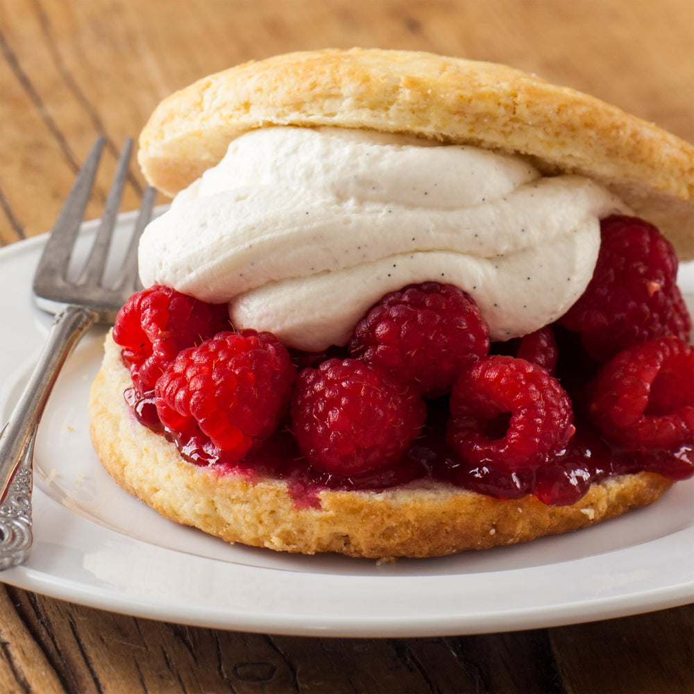 Stonewall Kitchen Seedless Raspberry Jam glass jar shine highlights premium fruit quality.