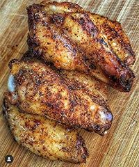 Pouring SuckleBusters Honey BBQ Rub for even pork rib glaze