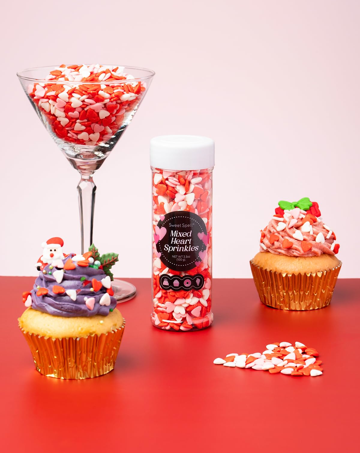 Sweet Spell heart sprinkles on cupcakes for festive flair.