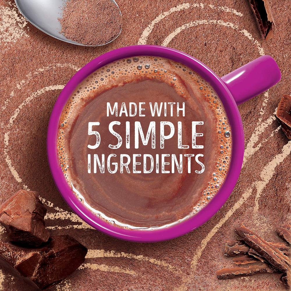 Pouring hot milk into Swiss Miss cocoa for a rich, smooth cup.