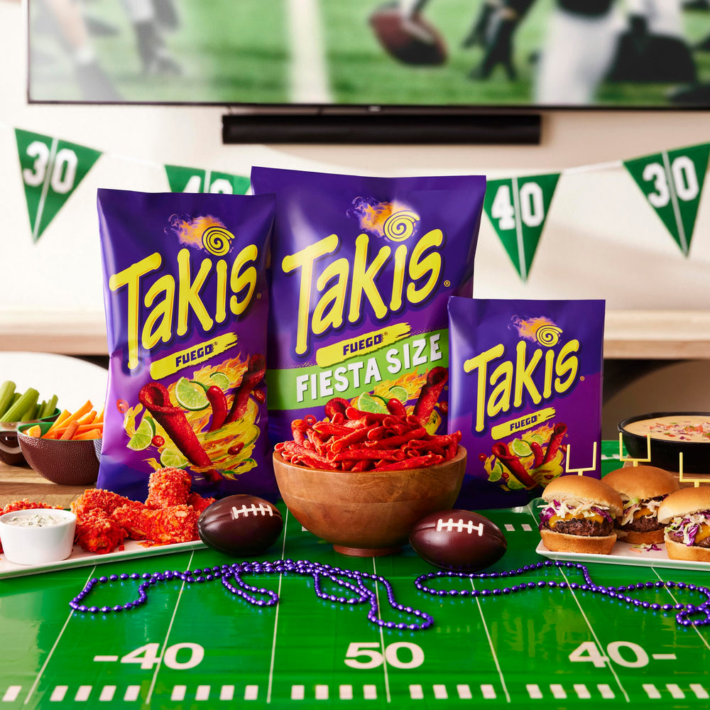 Takis Fuego chips on a table at a backyard BBQ.