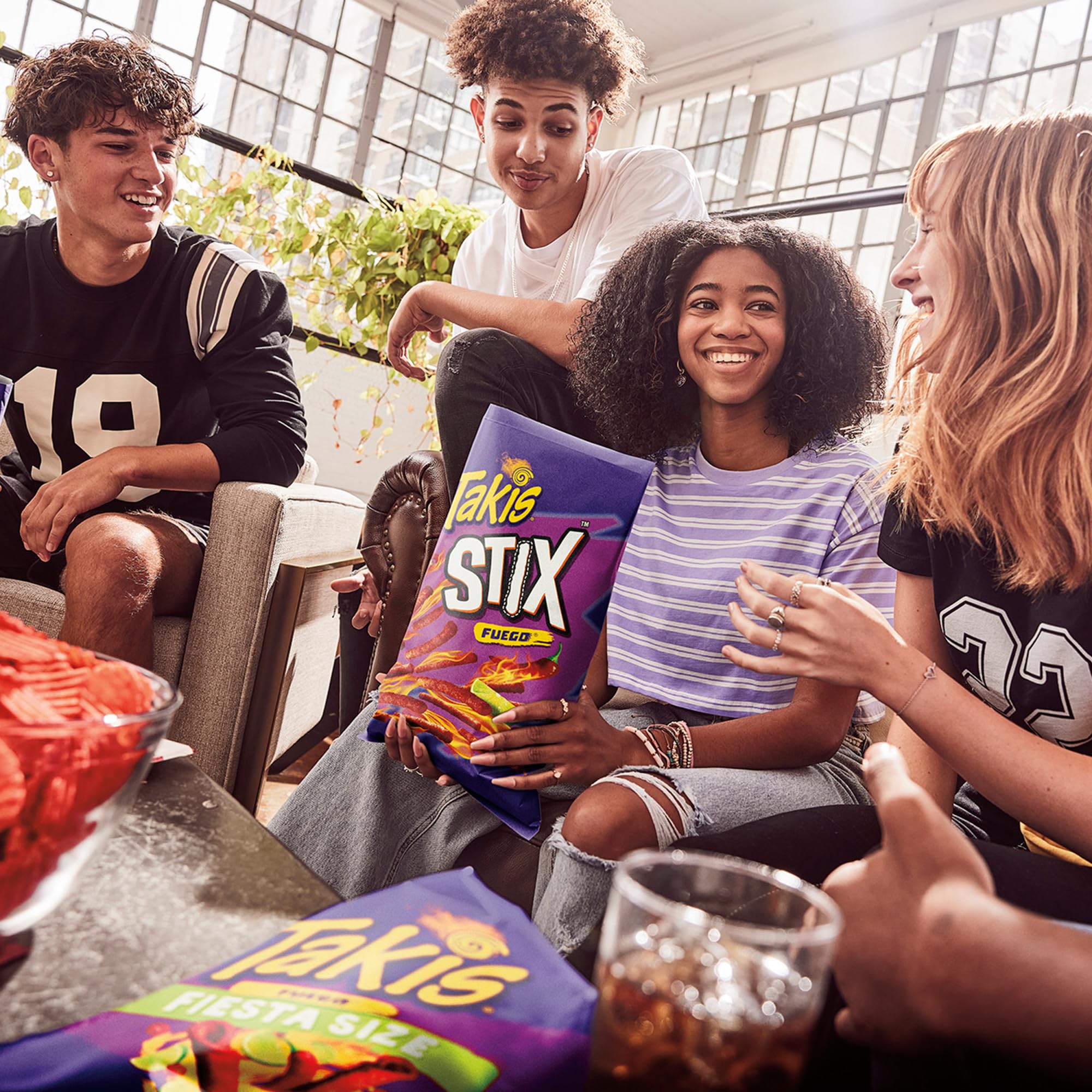 Takis bag on table with friends, brand visible and creates party energy