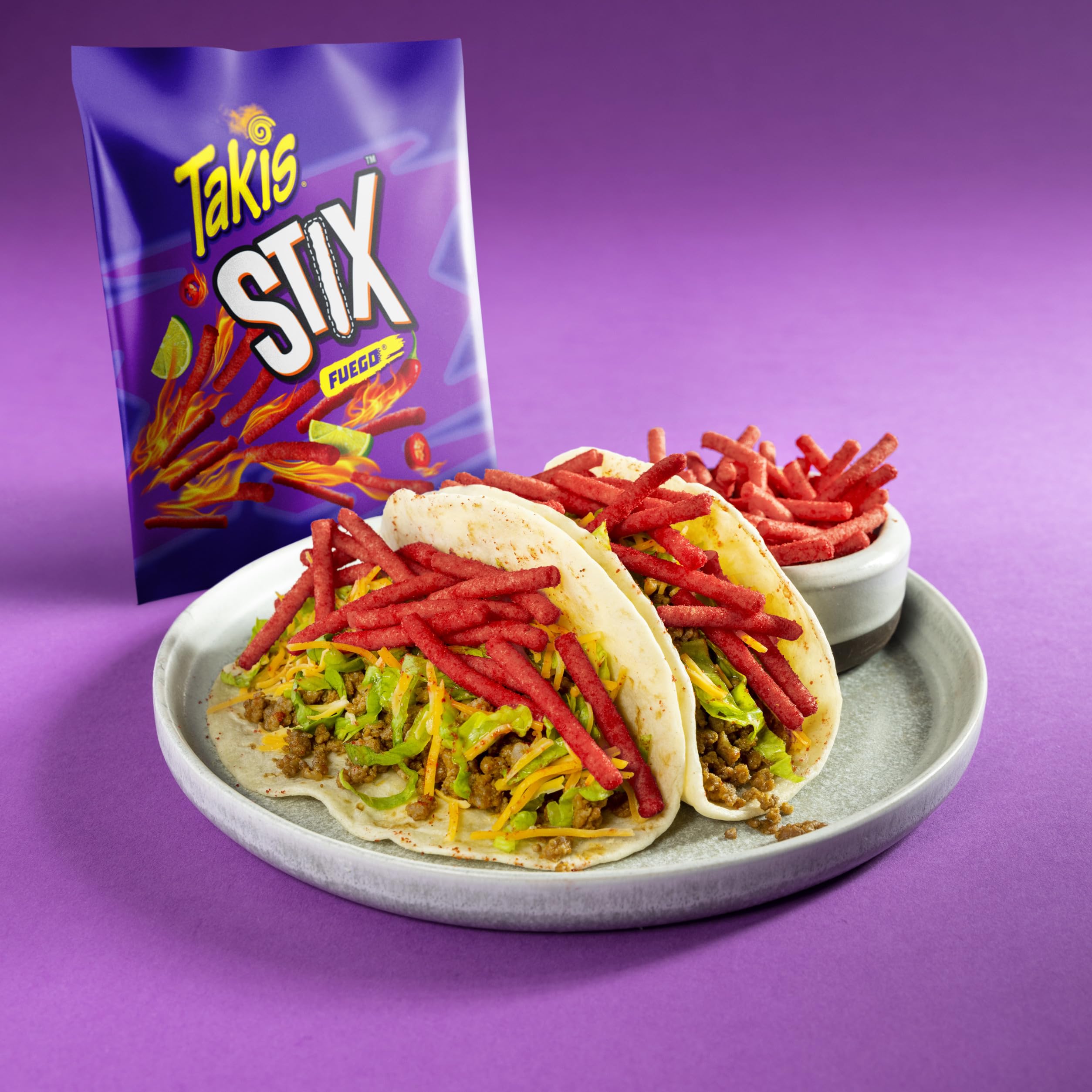 Takis Fuego Stix beside a soda can showing compact snack-size scale