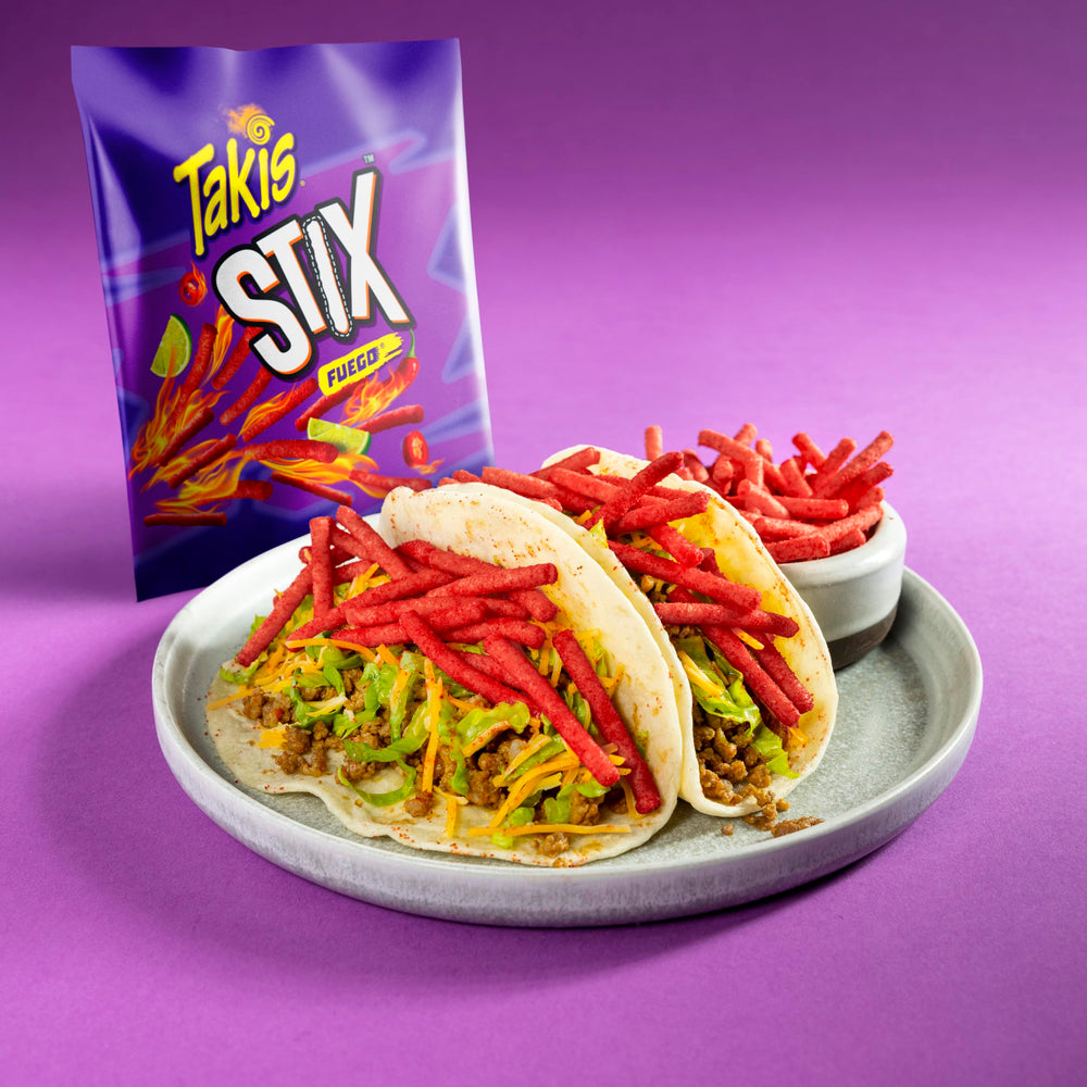 Takis Fuego Stix beside a soda can showing compact snack-size scale