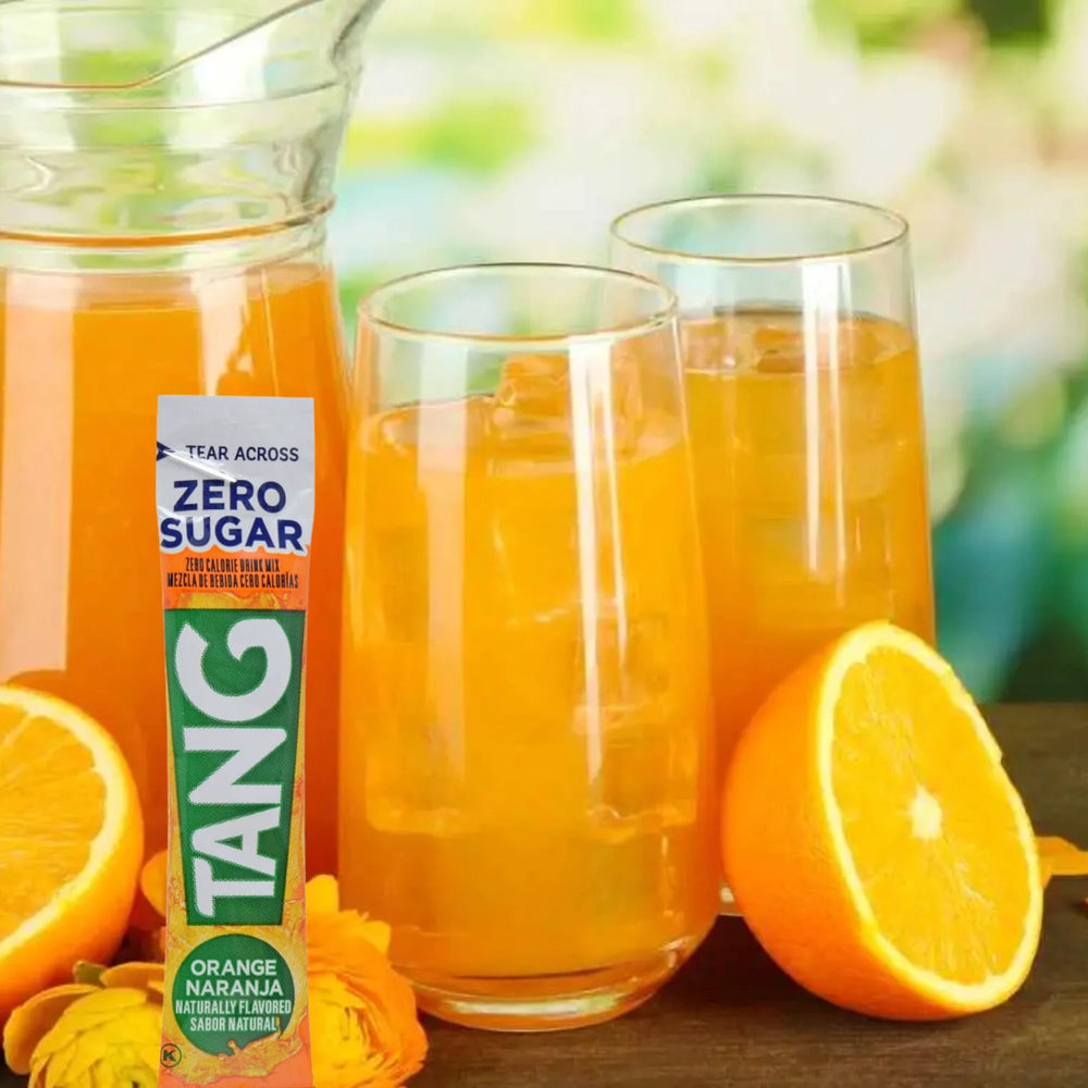 Bright orange Tang drink in a glass, ready to sip.
