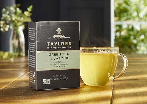 Taylors of Harrogate jasmine flowers over green tea leaves close-up.