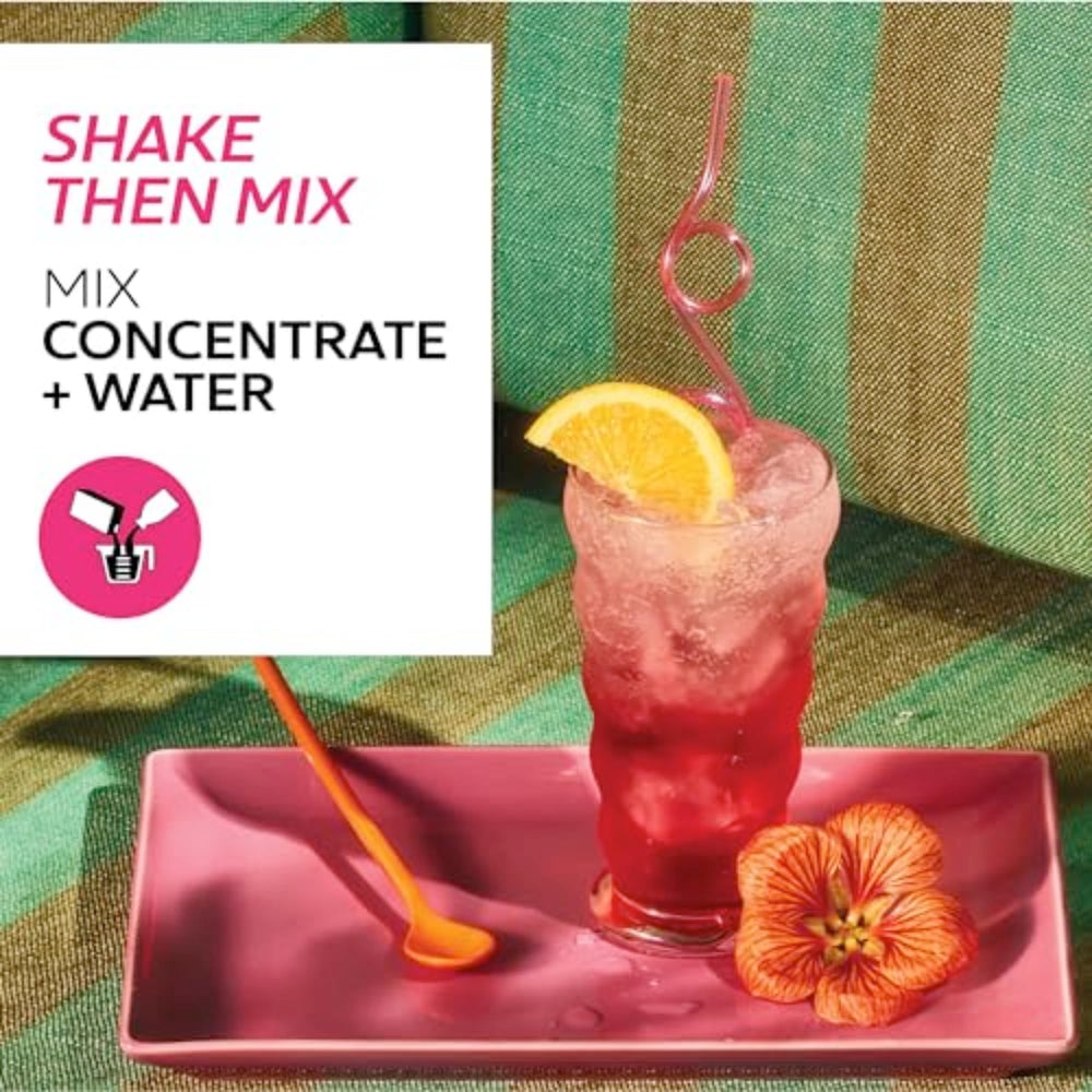 Glass with orange garnish beside TAZO Iced Passion for a bright mocktail base.