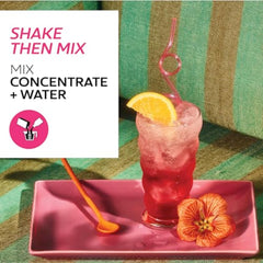 Glass with orange garnish beside TAZO Iced Passion for a bright mocktail base.