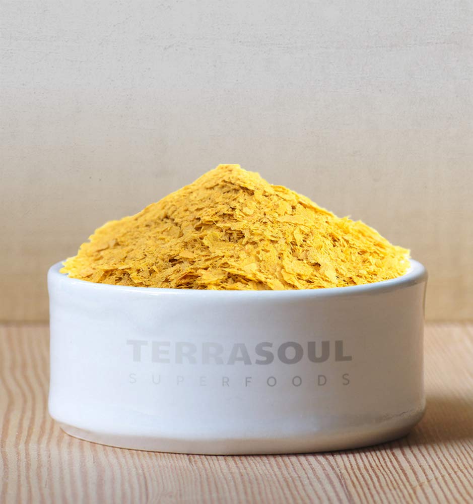 Terrasoul nutritional yeast in bowl with scoop, ideal for vegan cheesy toppings.