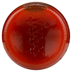 Texas Pete Hotter Hot Sauce being poured over nachos for flavor.