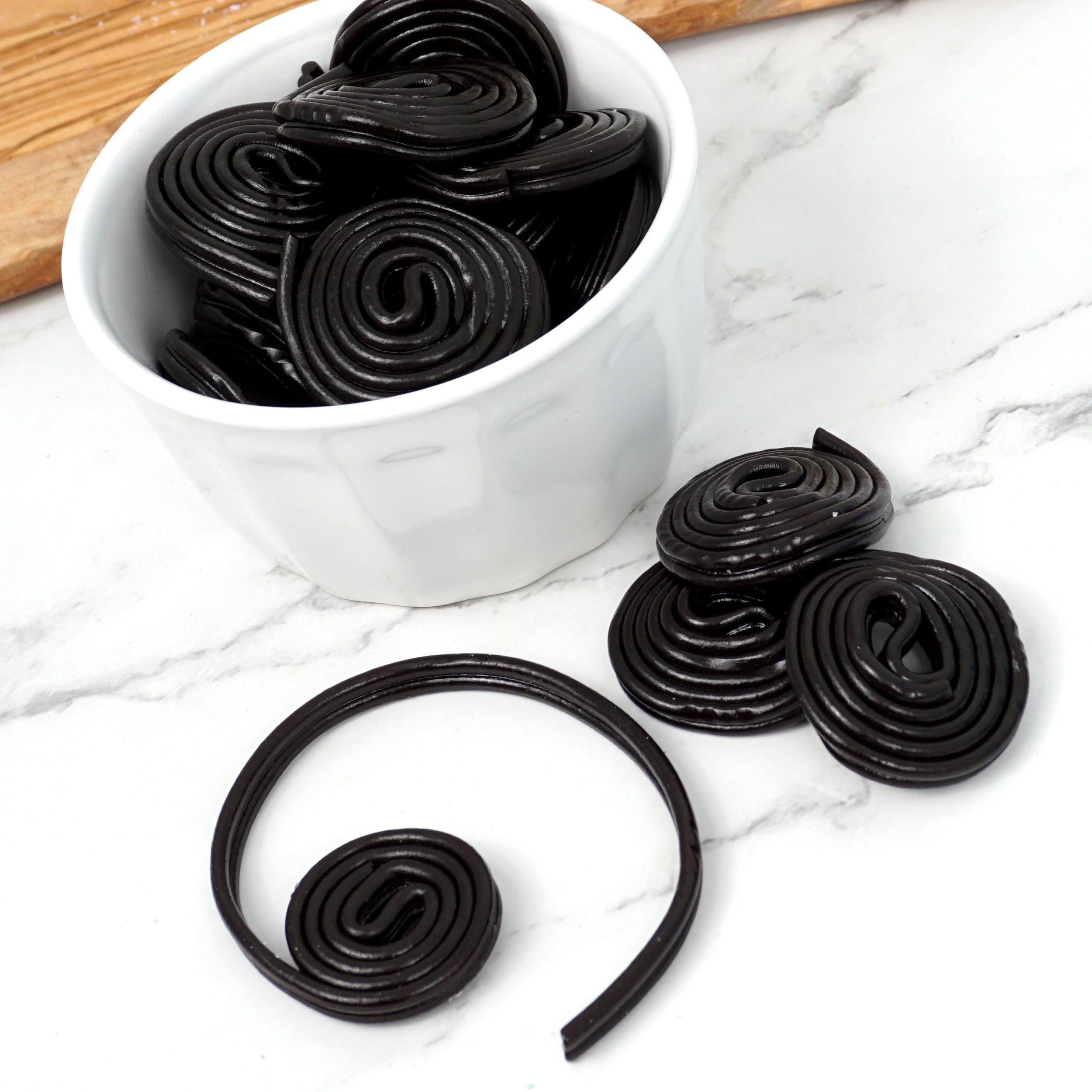 Broadway Black Licorice Wheels unrolled on a plate, highlighting chewy texture and bite-sized pieces.