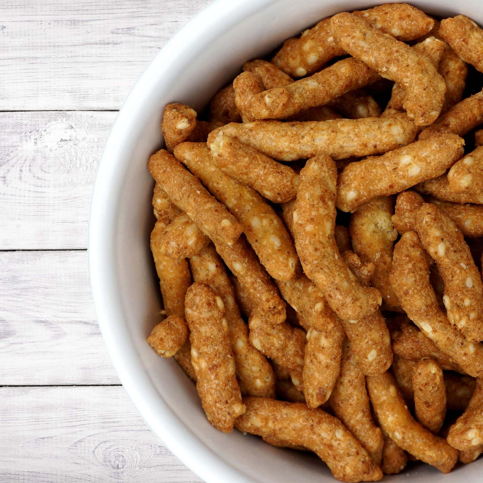 Honey roasted sesame sticks on a plate, ideal for gatherings and parties.