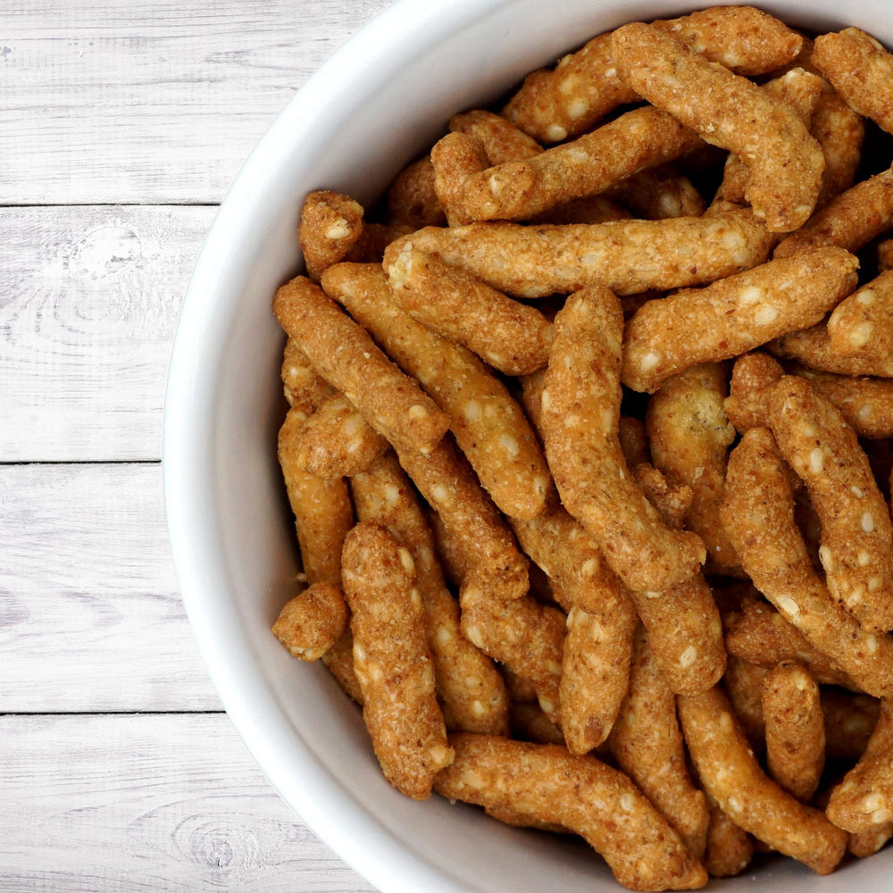 Honey roasted sesame sticks on a plate, ideal for gatherings and parties.