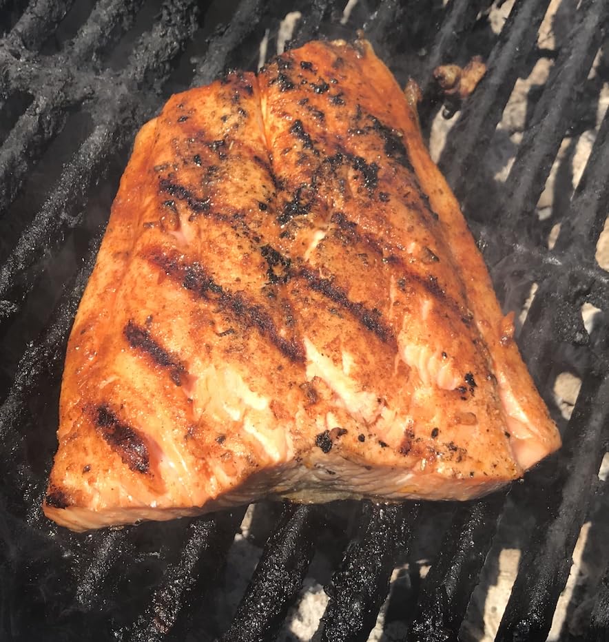 The Jerk Man seasoning sprinkled on a fish fillet for flavor.