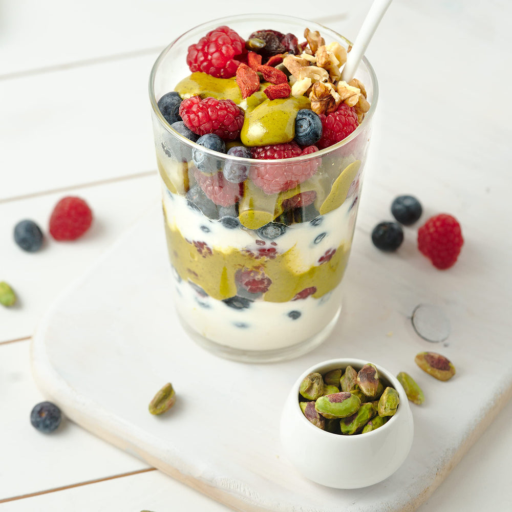 Dipping fruit into The Pistachio Factory pistachio butter for a healthy snack.