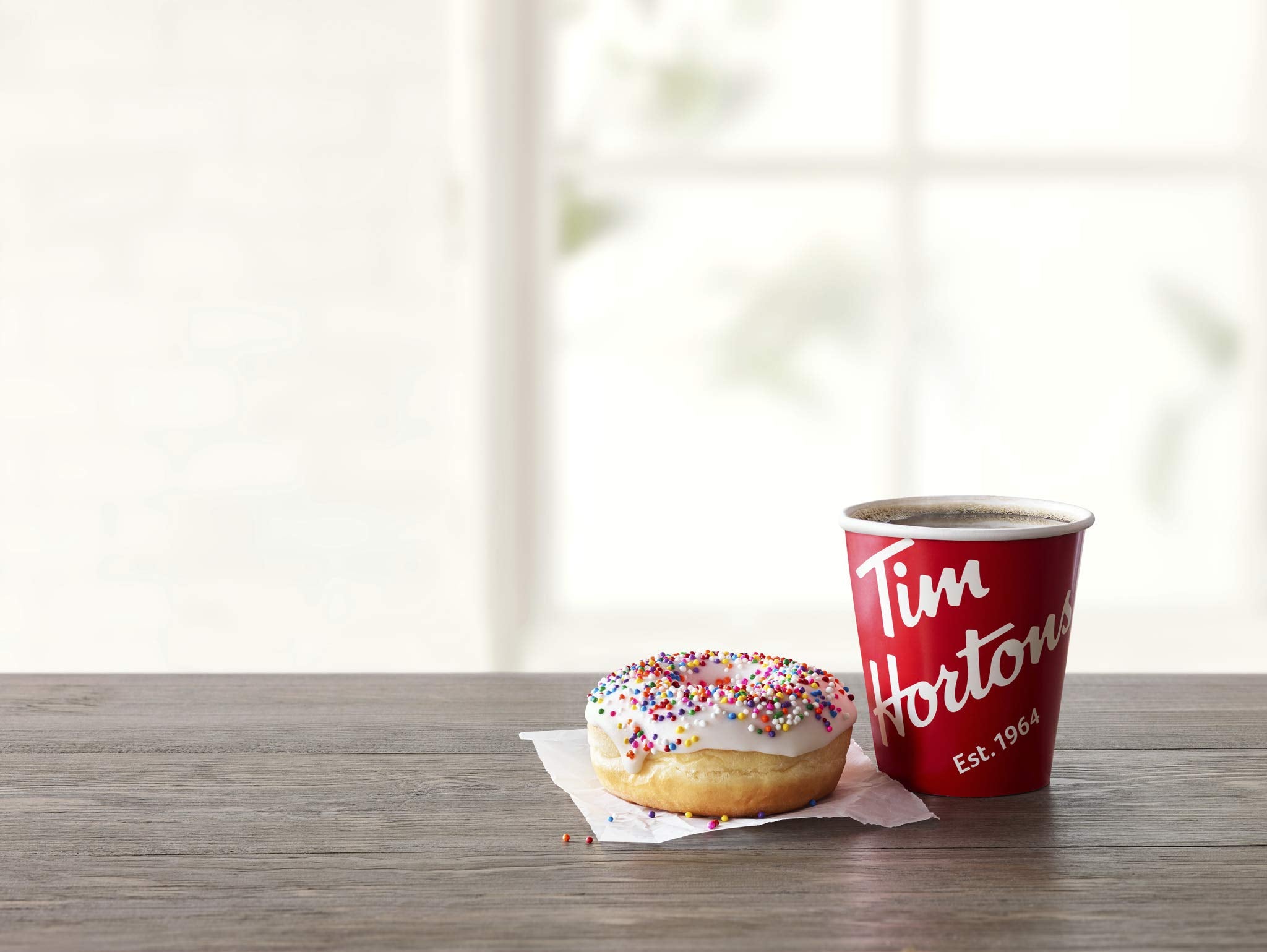 Pouring Tim Hortons dark roast coffee into a mug under a steady stream