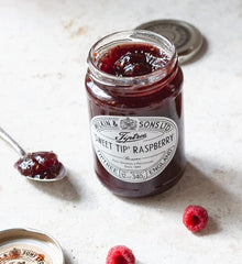 Tiptree preserve paired with Brie on a cheeseboard for an elegant bite