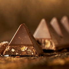 Toblerone nougat texture close-up showcases almond crunch within milk chocolate delightful.