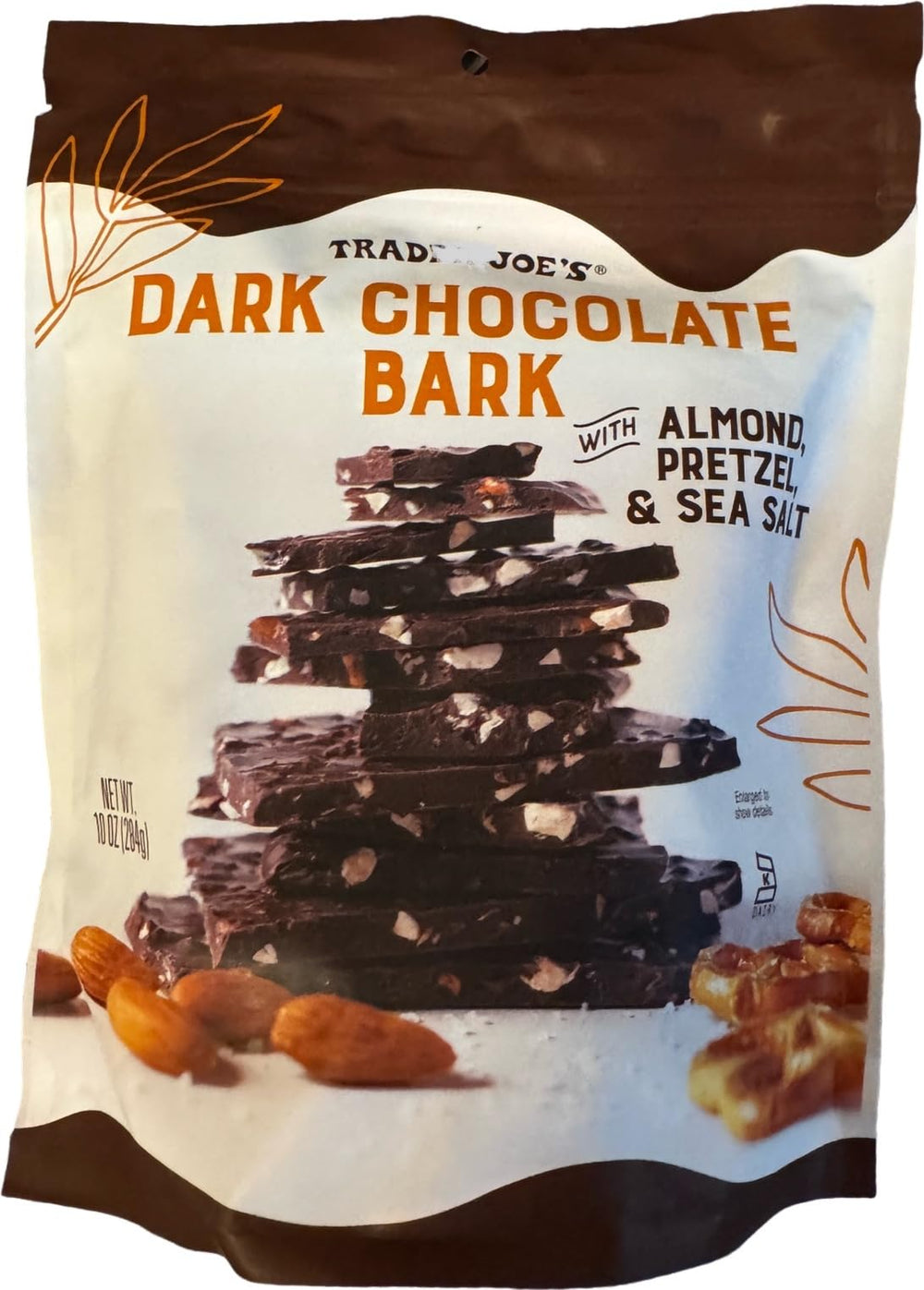 Trader Joe's dark chocolate bark with almonds and pretzels on a wooden board, ideal for entertaining