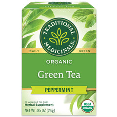 Traditional Medicinals green tea peppermint bag on a saucer, inviting refreshing aroma.