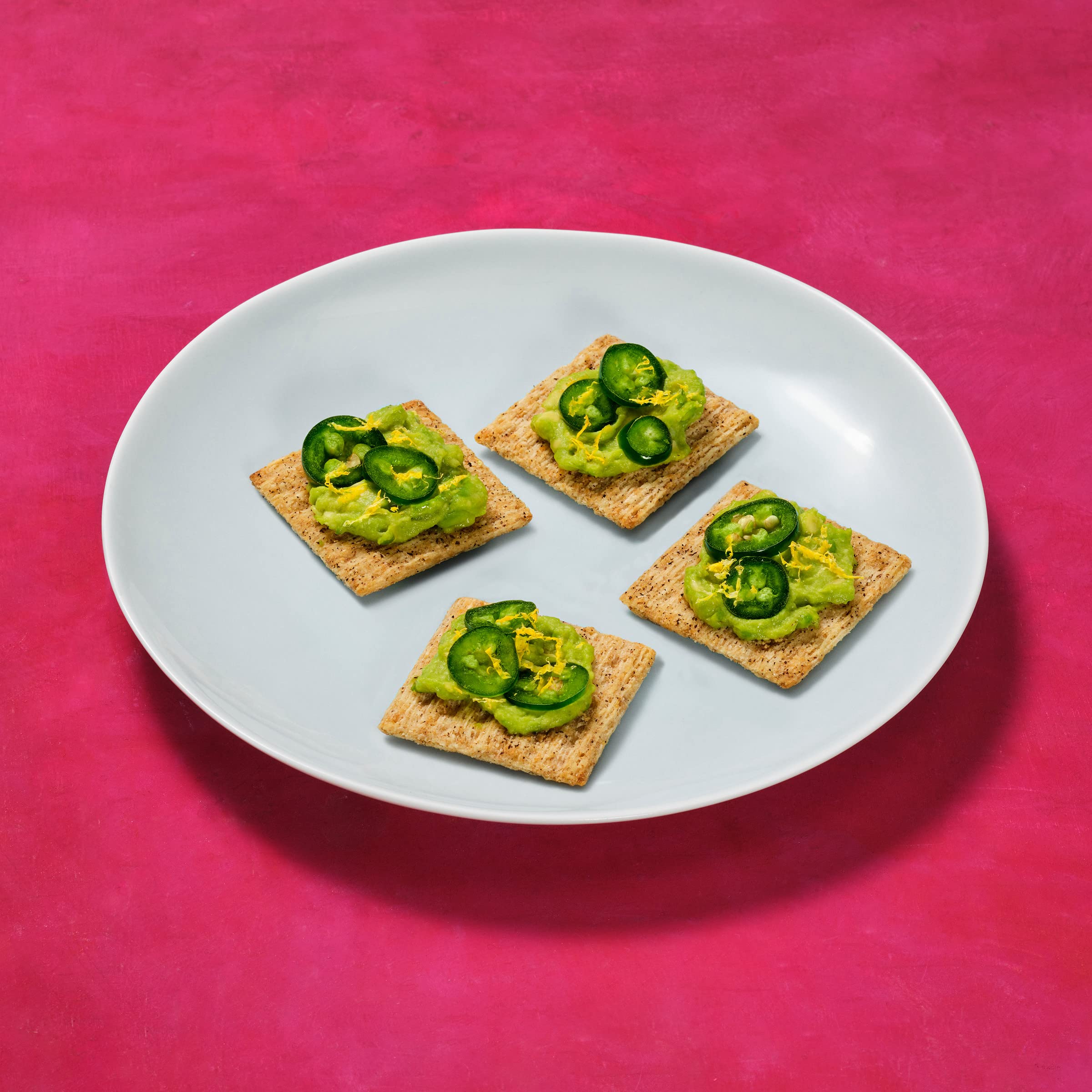Triscuit crackers paired with fruit and spreads for quick hors d'oeuvres.
