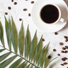 Two Rivers Chocolate Coconut ground coffee being poured into a filter for drip coffee.