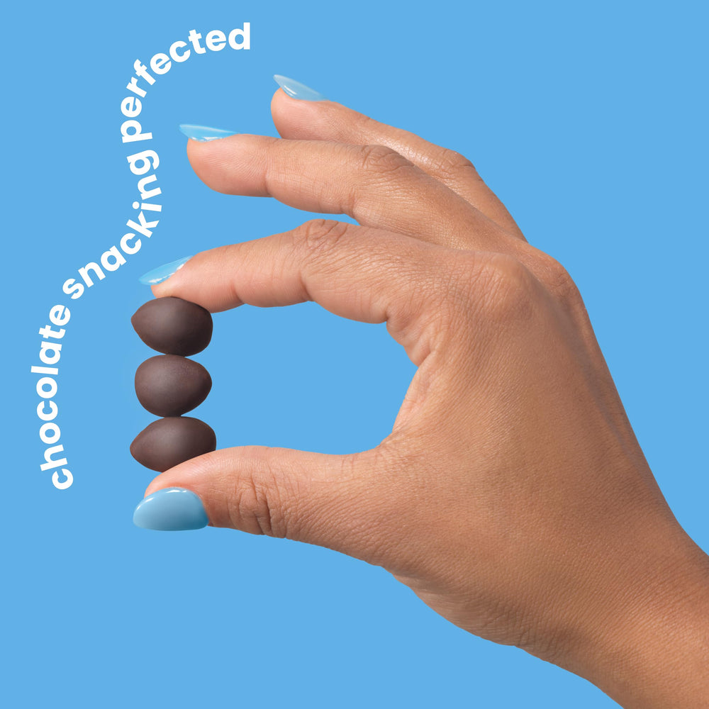 UNREAL Dark Chocolate Almonds on a desk for on-the-go snacking.